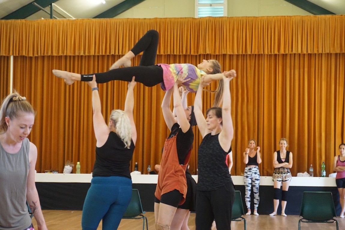 Supporting each other in more ways than one ... dancers from our performing company in rehearsal.  Foreground dancers lifting another dancer while others cheer them on from the sidelines